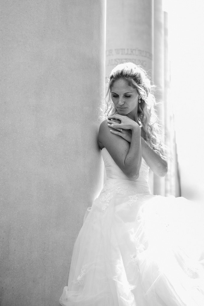 Braut in einem eleganten weißen Kleid, ihre Haltung ist sanft und verträumt.