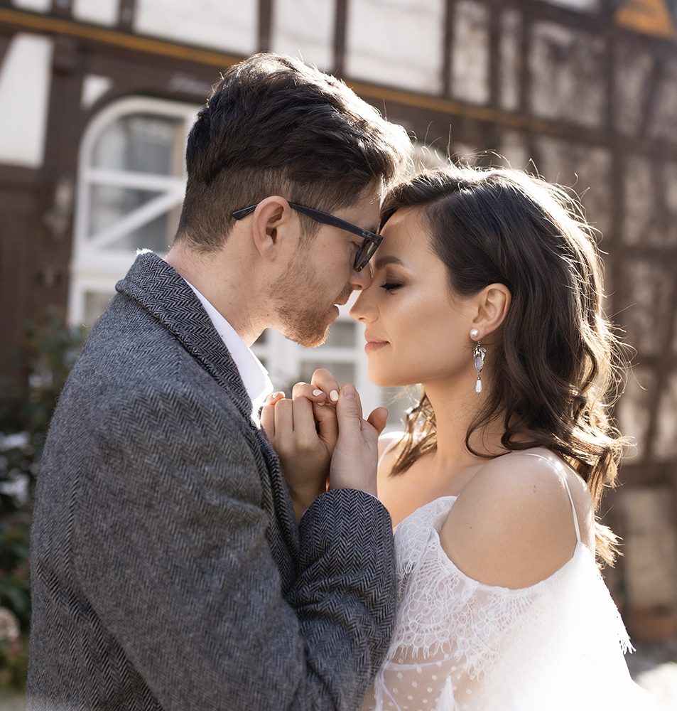 Ein Brautpaar steht sich nah gegenüber, beide mit gefühlvollem Blick und romantischer Atmosphäre.