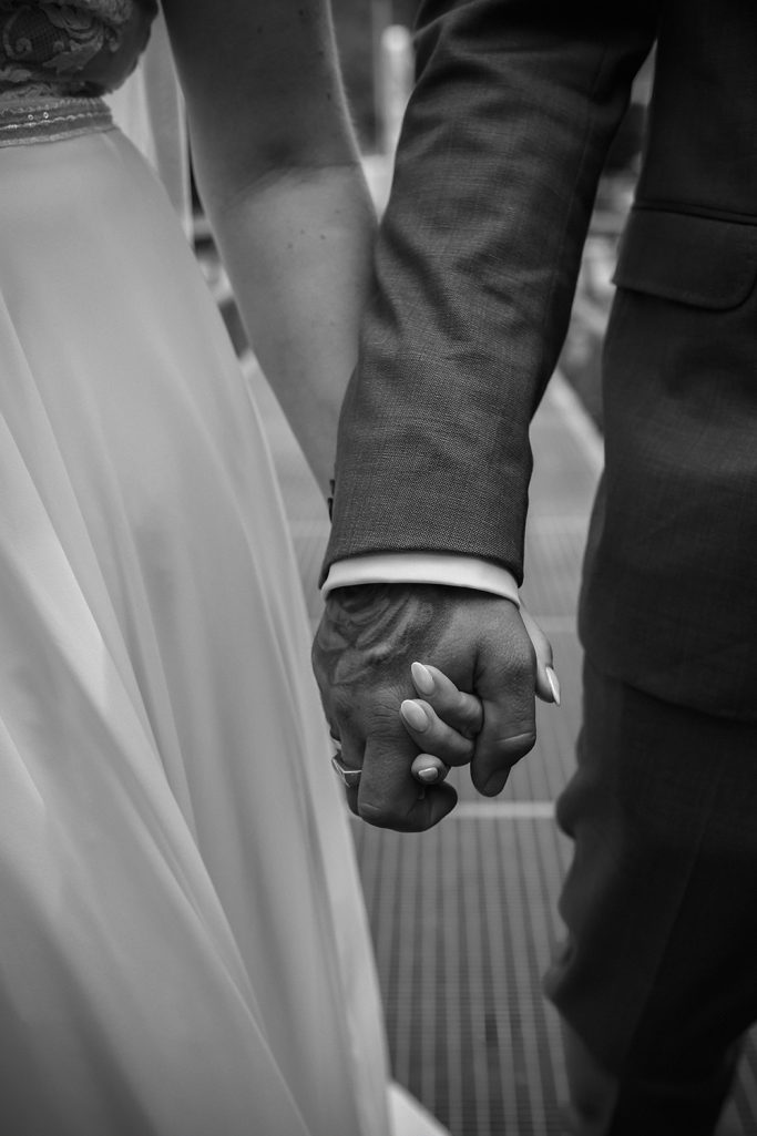 Händchenhaltendes Brautpaar, romantische Stimmung.